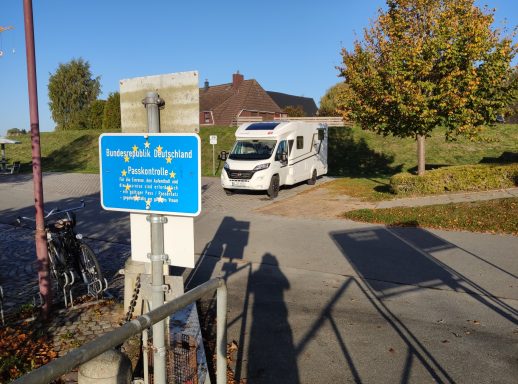 Landesgrenzschild hinter dem ein Wohnmobil steht