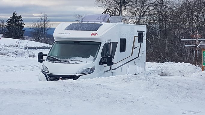 Wohmobil hinter Schneehügel